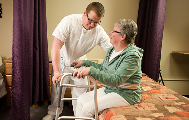 A Nursing Assistant Student Helping an Elderly Person