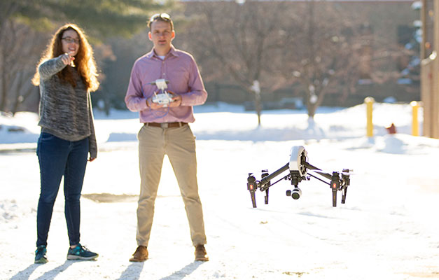 Two Students Flying a Drone in the Wintertime.