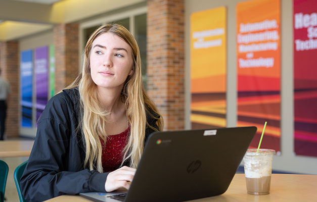 A Student Using a Computer in the Cafeteria. 