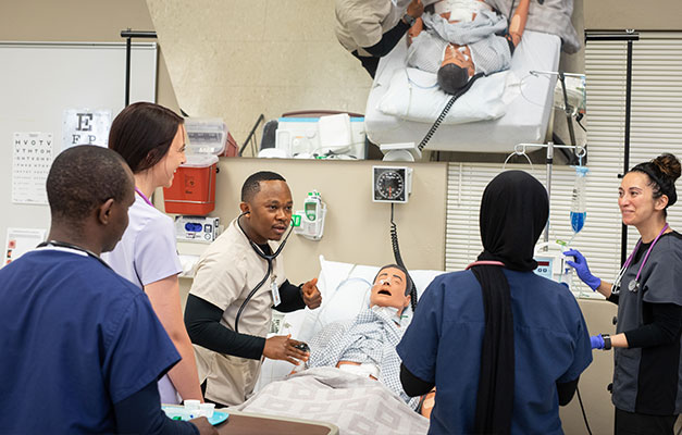 Practical Nursing Students Using a Mannequin to Practice Procedures. 