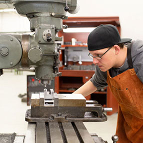 A Construction Student Using a Machine in the Lab.