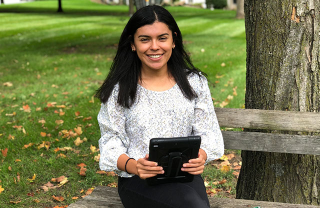 Melissa Vega sitting on bench with digital tablet