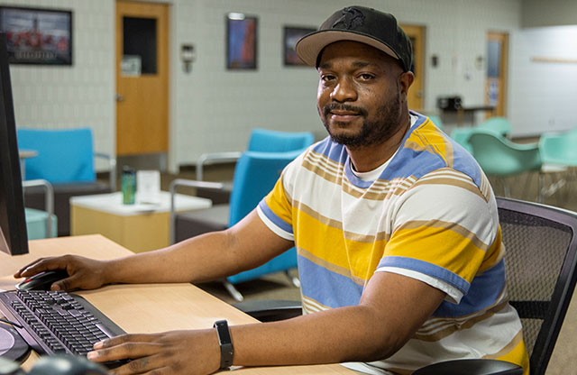 Cortez Whitaker seated at computer desk