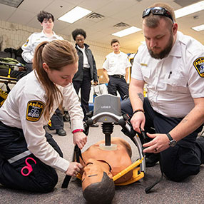 Two EMT Students Working on a Mannequin.