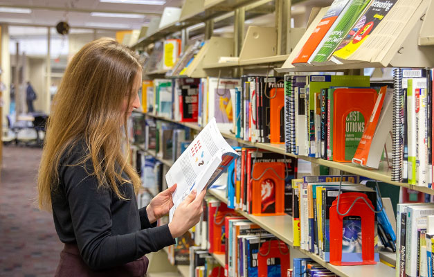 Student Reading a Book in the Library