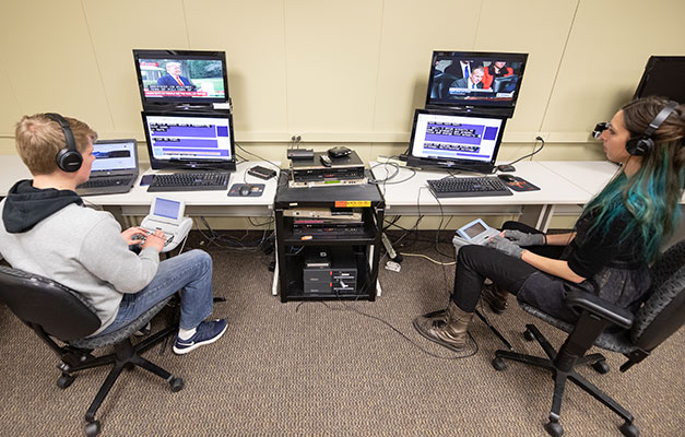 Two Students Practicing with the Captioning Devices.